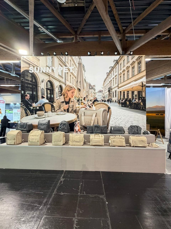 SUNNYPET Interzoo 2026 — khaki eco-friendly recycled pet carrier collection with European cafe lifestyle backdrop