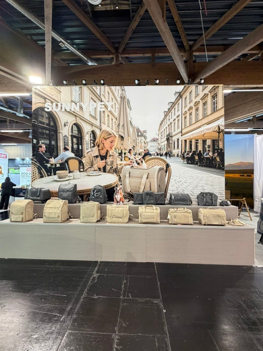 SUNNYPET Interzoo 2026 — khaki eco-friendly recycled pet carrier collection with European cafe lifestyle backdrop